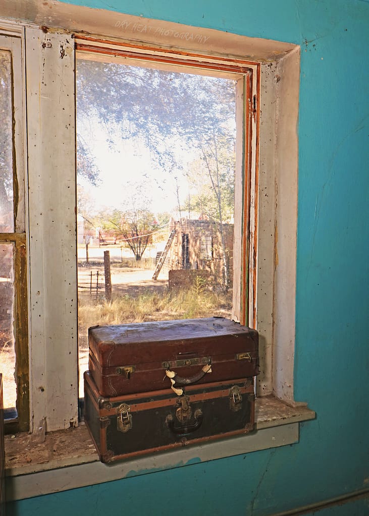 Old suitcases in the window of the abandoned Kuhn Hotel in Belen, New Mexico.